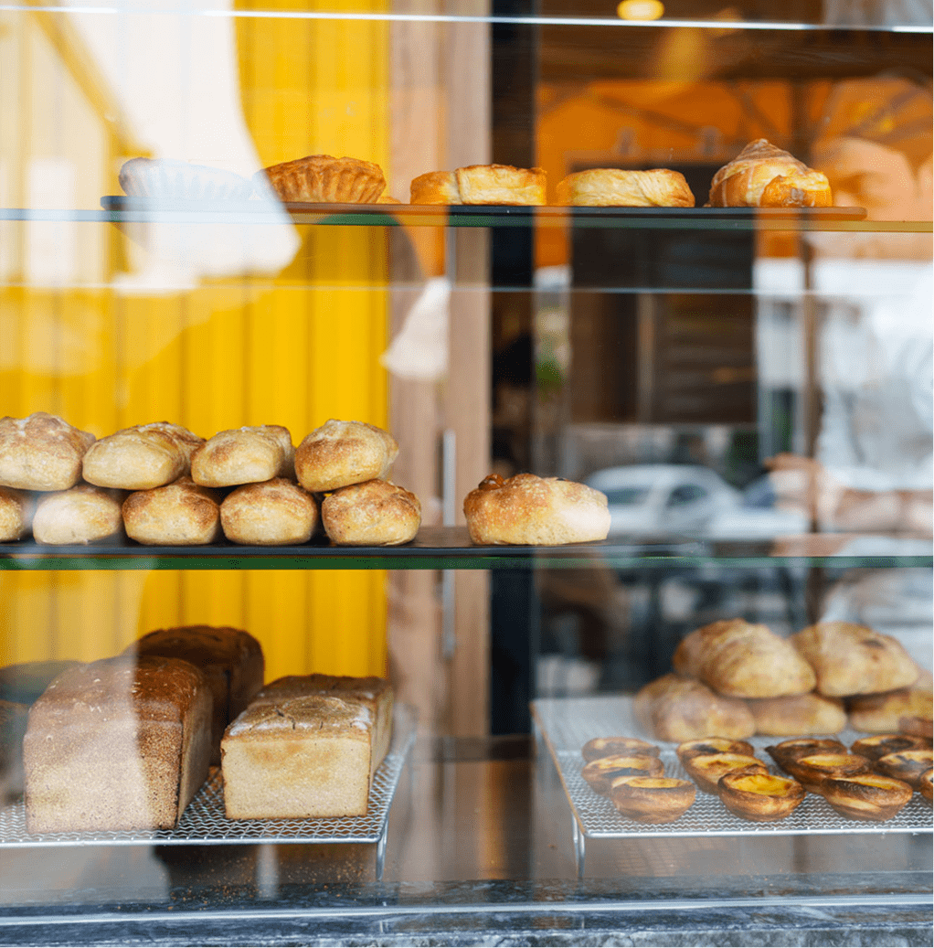 Assorted baked goods on glass shelves.