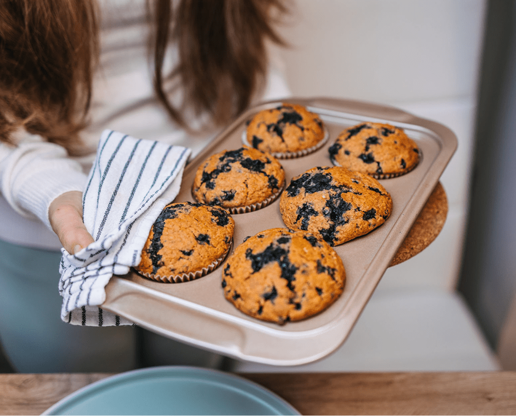 Homemade muffins with blueberries in kitchen